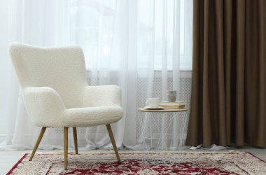 Yumuşak koltuk, yan masa ve perdeleri kapalı pencere. İç tasarım