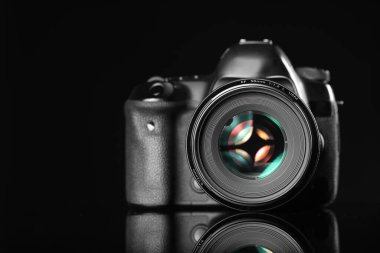 Siyah ayna yüzeyinde modern bir fotoğraf makinesi.