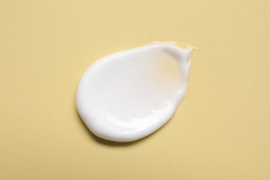 Soluk sarı arka planda yüz kremi, üst manzara