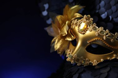 Koyu mavi arka planda güzel bir altın karnaval maskesi, yakın plan. Metin için boşluk