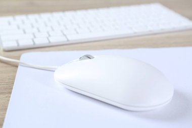 Ahşap masa üzerinde fare ve klavyeli beyaz bilgisayar faresi, yakın plan