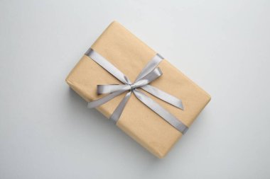 Gri arka planda saten fiyonklu hediye kutusu, üst görünüm