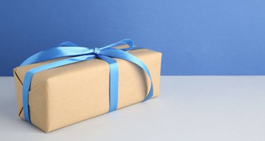 Arka planda mavi saten fiyonklu hediye kutusu. Metin için boşluk