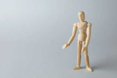Gri arka planda ahşap insan modeli, metin için boşluk. Mini manken.