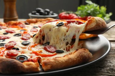 Tahta masada lezzetli bir pizza yiyorum, yakın plan.