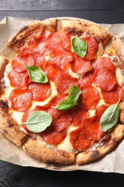 Lezzetli biberli pizza, fesleğen ve ahşap masa, üst manzara.