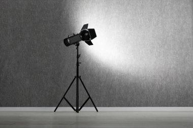 Stüdyoda gri fotoğraf arkaplanı ve profesyonel ışıklandırma ekipmanı, metin için boşluk