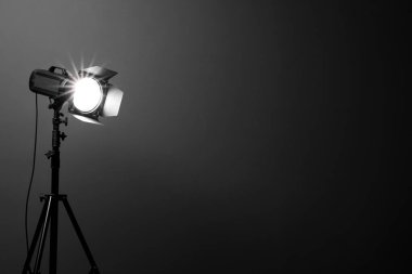 Stüdyoda koyu renk fotoğraf arkaplanı ve profesyonel ışıklandırma ekipmanı, metin için boşluk