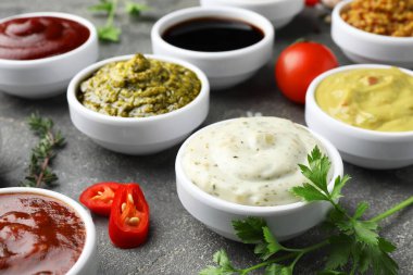 Gri masada birçok farklı sos ve baharat var. Yakın plan.