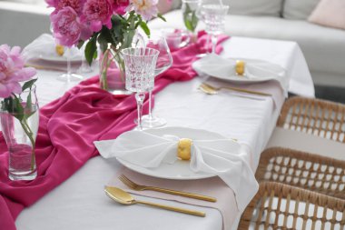 Beautiful table setting with pink peonies in dining room