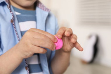 Küçük çocuk içeride hamurla oynuyor, yakın plan.