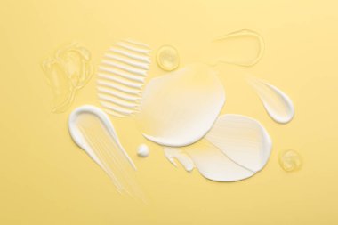 Sarı arka planda yüz kremi örnekleri, üst manzara