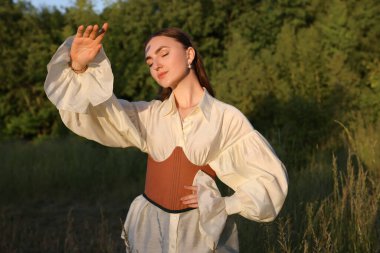 Dışarıda poz veren şık korseli güzel bir kadın.