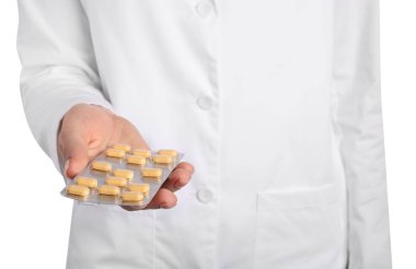 Beyaz arka planda antibiyotik haplı su toplayan doktor.