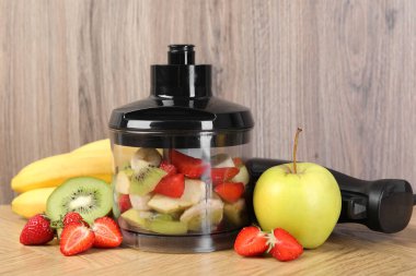 El blender seti, taze meyve ve çilek ahşap masada.