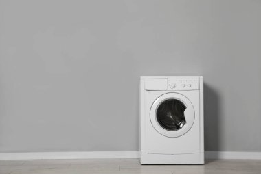 Gri duvarın yanında çamaşır makinesi, metin için boşluk
