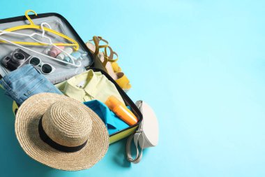 Açık mavi arka planda gezginlerin eşyalarının olduğu bavulu aç. Metin için boşluk