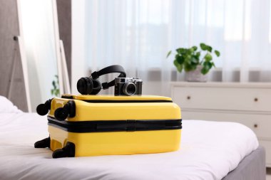 Sarı bavul, kulaklıklar ve kapalı alanda eski model kamera.