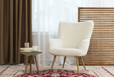 Yumuşak koltuk, sehpa ve odada perdeleri olan pencere. İç tasarım