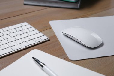 Fare ad, defter, kalem ve bilgisayar klavyeli kablosuz fare ahşap masa, yakın plan