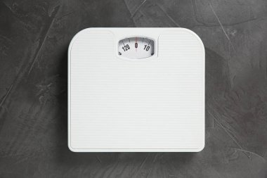 Gri desenli arka planda bir banyo terazisi, üst manzara.