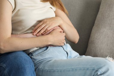 Kanepede kız arkadaşına sarılan bir adam.