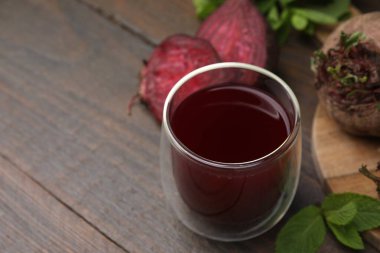 Bardakta taze pancar suyu, olgun sebzeler ve ahşap masada nane şekeri, yakın plan. Metin için boşluk