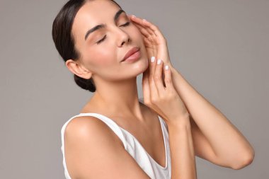 Gri arka planda iç çamaşırlı, mükemmel ciltli güzel bir kadın. Vücut bakımı