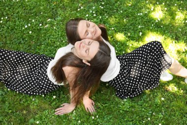 İki güzel ikiz kardeş birlikte parkta vakit geçiriyorlar.