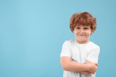 Açık mavi arka planda şirin küçük bir çocuğun portresi, metin için boşluk