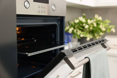 Mutfakta havluyla elektrikli fırını aç. Yemek pişirme aygıtı