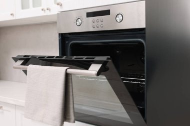 Mutfakta havluyla elektrikli fırını aç. Yemek pişirme aygıtı