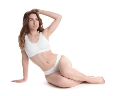 Beyaz arka planda poz veren ince vücutlu kadın.