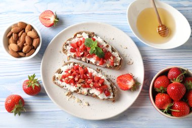 Ricotta peyniri, doğranmış çilek ve mavi ahşap masada nane şekeri.