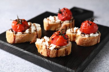 Gri masadaki ricotta peynirli, domatesli ve balzamik soslu