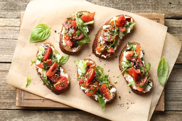 Lezzetli ricotta bruschetta domatesli, roka ve fesleğenli ahşap masa, üst manzara