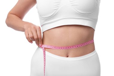 Diyet ve kilo verme konsepti. Elinde bant olan kadın zayıf vücudunu beyaz arka planda gösteriyor, yakın plan.