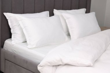 Evdeki yatakta bir sürü yumuşak yastık, yakın çekim.