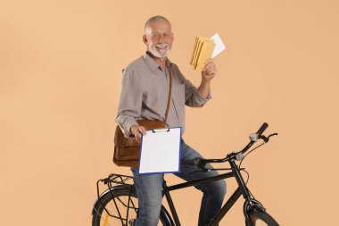 Bisikletli mutlu postacı bej arka planda mektuplar getiriyor.