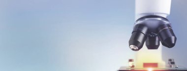 Mavi arka planda mikroskop, yakın plan. Metin için alanı olan pankart tasarımı