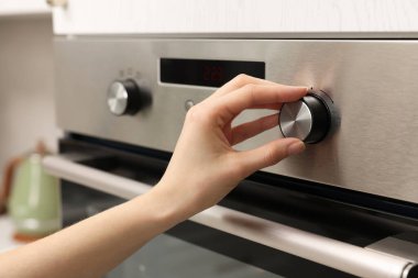 Mutfakta elektrikli fırın kullanan kadın, yakın plan.