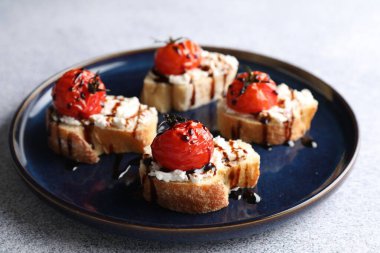 Gri masadaki ricotta peynirli, domatesli ve balzamik soslu