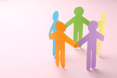Eşitlik kavramı. Pembe arka planda kağıt insan figürleri, yakın plan. Metin için boşluk
