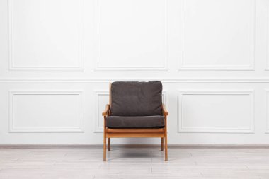 Beyaz duvarın yanında rahat bir koltuk.