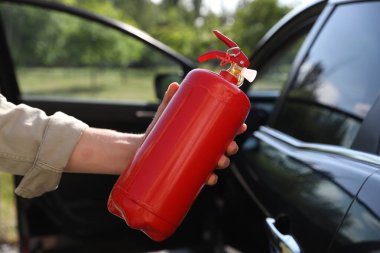Yangın söndürücülü adam, yakın çekim. Araba güvenliği ekipmanı