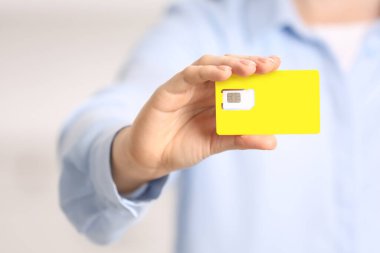 Modern SIM kartı elinde tutan kadın, yakın plan.