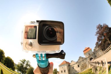 Modern aksiyon kamerası ve monopod açık hava kameralı adam, yakın plan. Fisheye lens etkisi