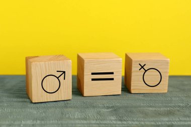 Sarı arka planda kadın ve erkek cinsiyet sembolleri arasında eşit işaret olan küp