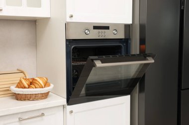 Mutfakta elektrikli fırın ve kruvasan aç. Yemek pişirme aygıtı