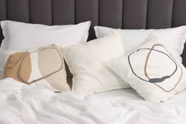 Evdeki yatakta bir sürü yumuşak yastık, yakın çekim.